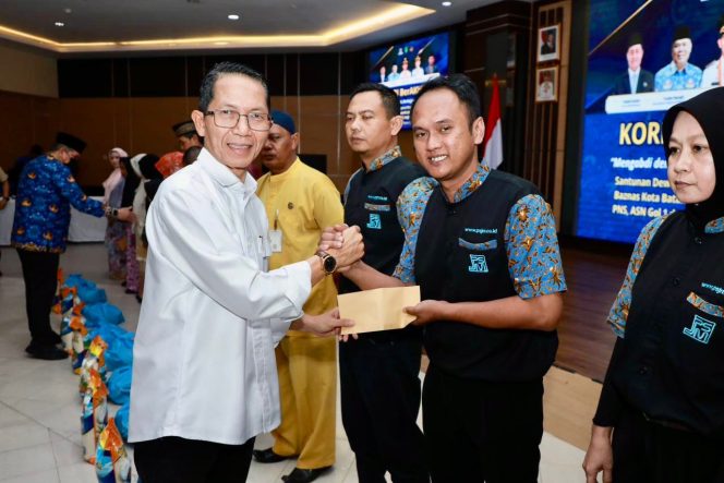 
					Wali Kota Batam, Amsakar Achmad, menyerahkan bantuan untuk petugas kebersihan di lingkungan Kantor Wali Kota Batam, Jumat (6/2/2026). HUMAS DISKOMINFO BATAM / DHEO ANANDA PUTRA