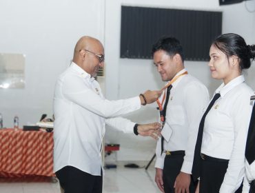Penjabat Sekdaprov Kepri, Luki Zaiman Prawira mengalungkan tanda peserta kepada perwakilan CPNS, sebagai tanda dimulainya rangkaian pelatihan dasar tahun 2026, di Gedung BPMP Ceruk Ijuk, Bintan, Kamis (23/4/2026).