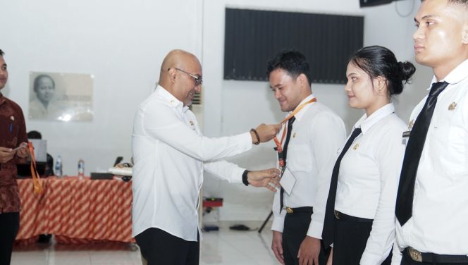 
					Penjabat Sekdaprov Kepri, Luki Zaiman Prawira mengalungkan tanda peserta kepada perwakilan CPNS, sebagai tanda dimulainya rangkaian pelatihan dasar tahun 2026, di Gedung BPMP Ceruk Ijuk, Bintan, Kamis (23/4/2026).