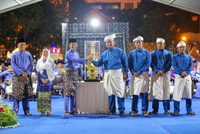 
					Wali Kota Batam, Amsakar Achmad, didampingi Wakil Wali Kota Batam, Li Claudia Chandra, dan Sekda Batam, Firmansyah, menerima kembali piala bergilir dari Kecamatan Sagulung saat malam pembukaan MTQH XXXIV di Dataran Engku Putri Batamcentre, Jumat (10/4/2026) malam.