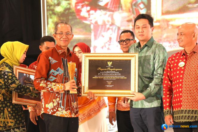 
 Wali Kota Batam, Amsakar Achmad, menyerahkan piagam kepada salah seorang wajib pajak saat Malam Apresiasi Wajib Pajak Kota Batam 2026 di Ballroom Harmoni One Hotel, Batamcentre, Senin (22/6/2026) malam. 