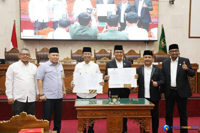 
 Wali Kota Batam, Amsakar Achmad, bersama pimpinan dan anggota DPRD Batam menunjukkan dokumen pengesahan Perda PSU usai Rapat Paripurna di Ruang Sidang Utama DPRD Kota Batam, Rabu (24/6/2026). 