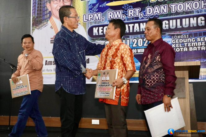 
 Wali Kota Batam, Amsakar Achmad, menyerahkan insentif RT, RW dan LPM di Gedung Serba Guna SP Plaza, Kecamatan Sagulung, Senin (6/7/2026) malam. 