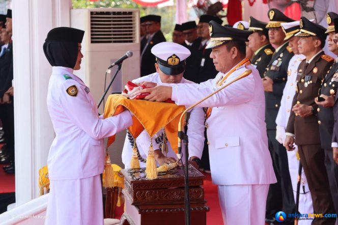 
 Gubernur Kepulauan Riau Ansar Ahmad menyerahkan Bendera Merah Putih kepada Yuanita Putri Verinda, pembawa baki Paskibraka dalam Upacara Peringatan HUT ke-81 Republik Indonesia di Gedung Daerah Tanjungpinang, Senin (17/8/2026). 