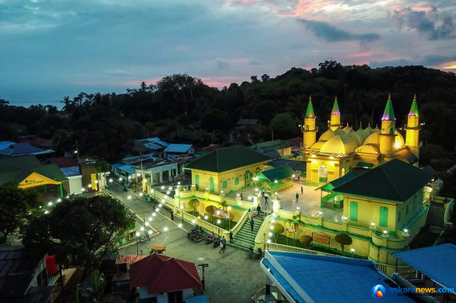 
 Komplek Balai Adat Pulau Penyengat di waktu malam dengan latar belakang Kota Tanjungpinang di waktu malam