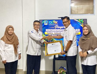 Sekretaris Diskominfo Kepri, James Simon Pattikawa didampingi Kepala Bidang Statistik dan Persandian Diskominfo Kepri Dwi Anggraini, menyerahkan Piagam Pengesahan Integrasi TTE Aplikasi SMART kepada Kepala DLHK Kepri Indra Hidayat, Kamis (22/10/2026). 